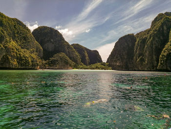 Scenic view of sea and mountains against sky