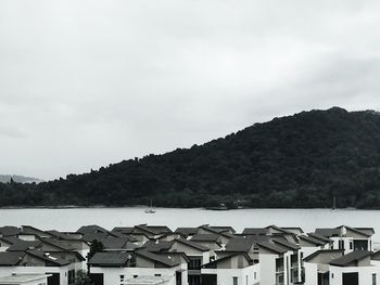 Houses by sea against mountain