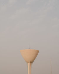 Low angle view of cocktail against wall against sky