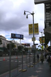 Road sign in city against sky