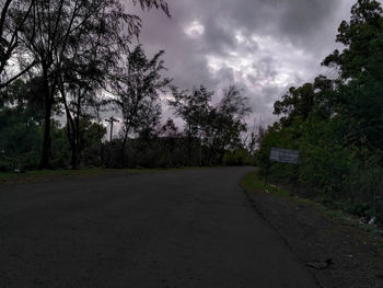 Road amidst trees against sky