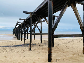 View of pier on beach against sky