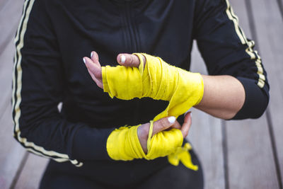 Midsection of woman with yellow bandage