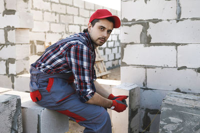 Portrait of man standing against wall