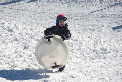 Boy with sled walking on snow