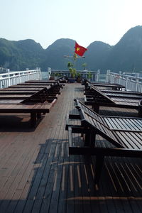 Lounge chairs on pier by mountains