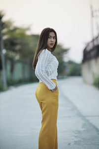 Young woman standing on road