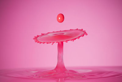 Close-up of water drops on glass against pink background