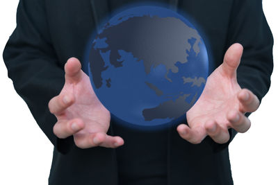 Digital composite image of man standing by globe map against white background