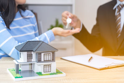 Midsection of woman holding umbrella on table in building