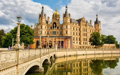 Arch bridge over river against buildings in city