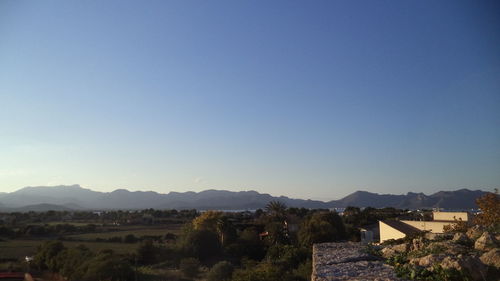 View of townscape against clear blue sky