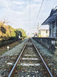 Railroad tracks against cloudy sky