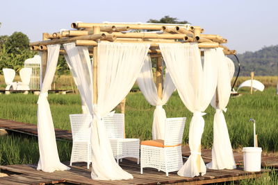 Chairs and table on field against sky
