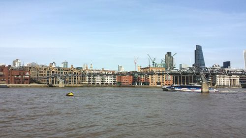 Boats in river with buildings in background