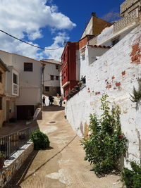 Houses by street in city against sky