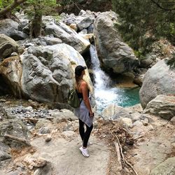 Woman standing in front of rock waterfall