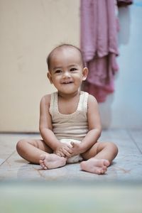 Portrait of cute baby boy lying on floor at home