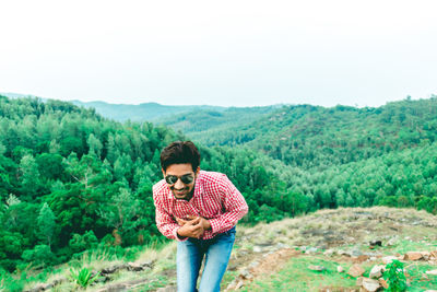 Full length of young man standing on land against sky