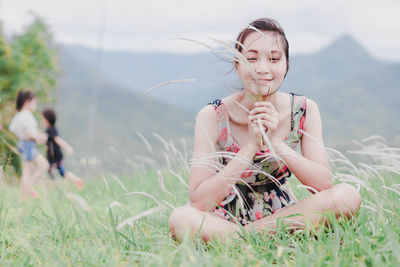 Young woman sitting on field