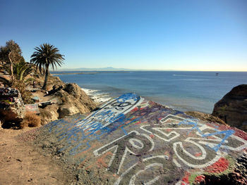 Graffiti on rock against sea
