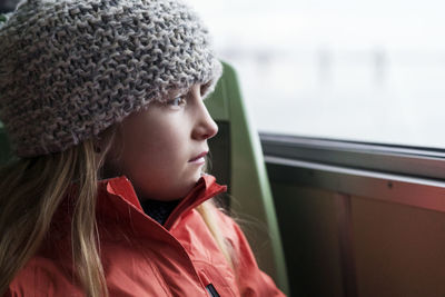 Close-up of girl looking through window