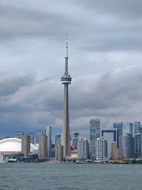 Modern buildings in city against cloudy sky