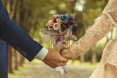 Cropped image of newlywed couple holding hands