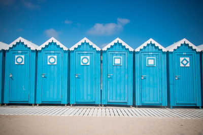 Closed wooden door of building against blue sky