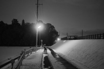 Illuminated street light against sky