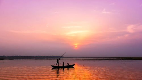 Silhouette boat in sea against sky during sunset