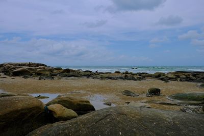 Rocks on beach against sky