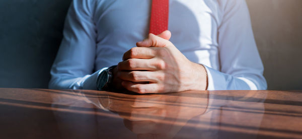 Midsection of man sitting on table