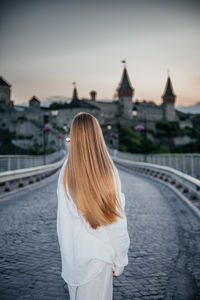 Rear view of woman standing against river