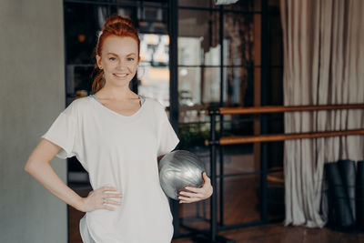 Portrait of smiling woman holding sports ball