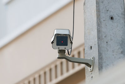 Low angle view of security camera on wall