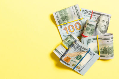 High angle view of various coins on yellow background