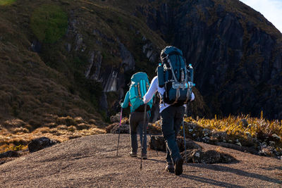 Rear view of people walking on rock