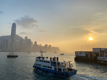 Scenic view of sea and buildings against sky during sunset