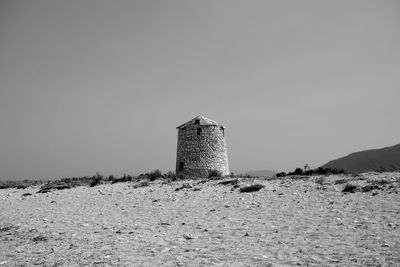 Panoramic view of traditional windmill on sandy coastline