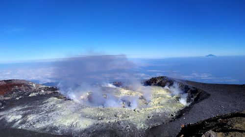 Panoramic view of volcanic landscape against blue sky