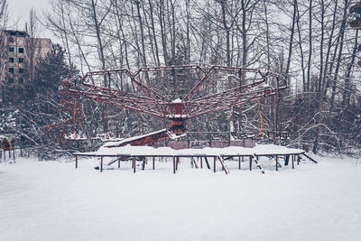 Outdoor play equipment in city against sky during winter
