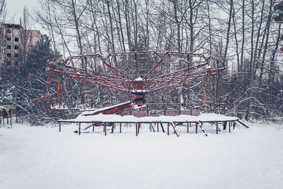 Bare trees on snow covered field