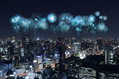 Firework display over illuminated buildings in city at night