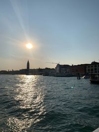 View of buildings by sea against sky during sunset