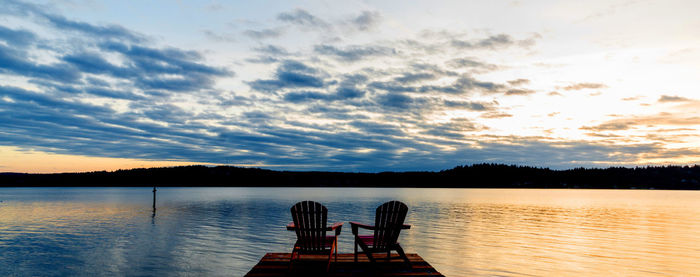 Silhouette pier on lake against sky during sunset