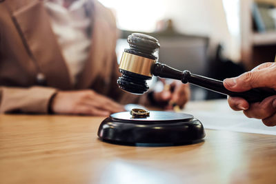 Close-up of judge hand banging gavel on table