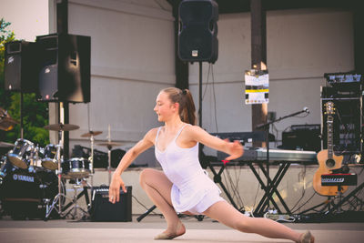 Full length of woman sitting on stage