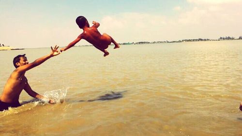 Rear view of woman jumping in sea