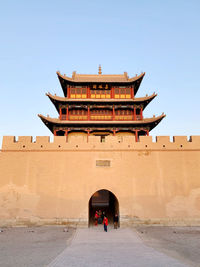 People in front of building against clear sky